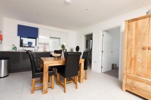 a kitchen and dining room with a wooden table and chairs at The Old Flower Field in Hurstpierpoint