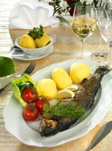 a plate of fish and vegetables on a table at Landgasthof "Zur Linde" in Dreba