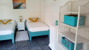 a bedroom with two twin beds and a shelf at Mi apartamento Mini 2 in Puerto Naos