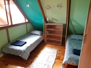 Una pequeña habitación con una cama y un espejo. en Pelagonia, en Bettyʼs Bay