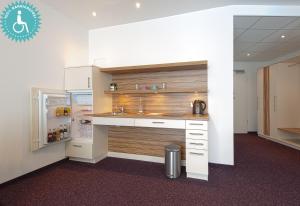 a kitchen with a counter and a refrigerator at Lichtblick Hotel Garni in Alling