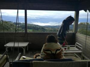 a woman standing on top of a room with a table at Al Bosque Hostel & Glamping in Santa Elena