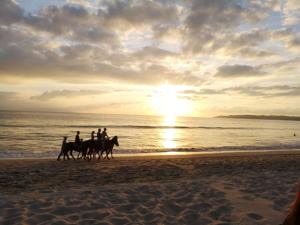 a group of people riding horses on the beach at sunset at Depto. Hanna #5 in Bucerías