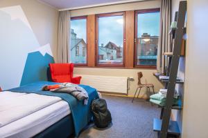 レイキャビクにあるLoft - HI Eco Hostelのベッドルーム1室(ベッド1台、椅子、窓付)
