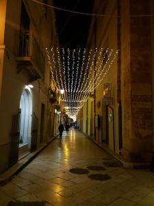 eine leere Gasse mit Lichtern, die von einem Gebäude hängen in der Unterkunft A casa di Alba in Marsala