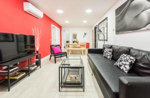 sala de estar con sofá negro y pared roja en Ever House - ALCALA AIRE Gran TERRAZA ROOFTOP, en Madrid