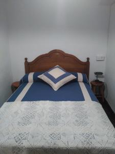 a bedroom with a bed with a blue and white comforter at Casa Gelina in Corras de la Puente