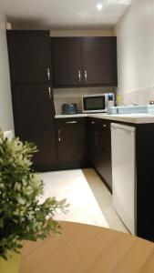 a kitchen with black cabinets and a white counter top at Swan Studios in Choppington