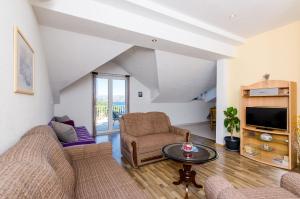 a living room with two couches and a tv at Apartments Zrno in Cavtat
