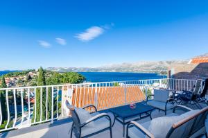 a balcony with chairs and a view of the ocean at Apartments Zrno in Cavtat