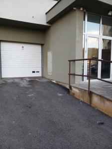 a garage with two white garage doors on a building at Apartman 3S Pale Jahorina in Pale