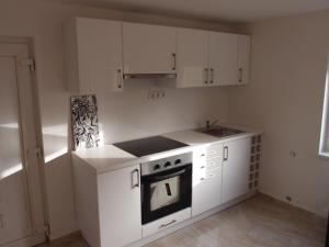 a kitchen with white cabinets and an oven at Sió Lodge in Siófok