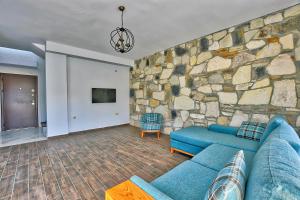 a living room with a stone wall and a blue couch at Vintage Villas in Kusadası
