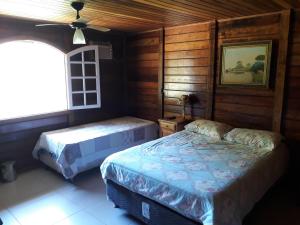 a bedroom with two beds and a window at Floresta Tropical in Barra de Guaratiba