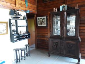an antique cabinet in a room with stools at Floresta Tropical in Barra de Guaratiba