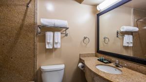 a bathroom with a toilet and a sink and a mirror at New Englander Inn Bennington in Bennington