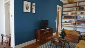 una sala de estar con paredes azules y un árbol de Navidad en una mesa en Casa Pé da Cabra, en Coímbra