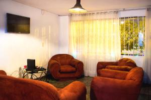 a living room with two chairs and a television at Bababuy Hostel in Bogotá