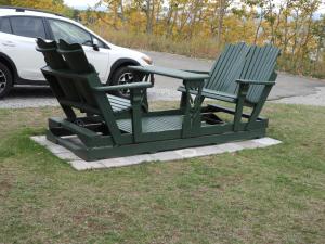 two green lawn chairs sitting next to a car at Hôtel Sous la Croix 152725 in Tadoussac