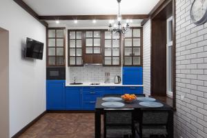 リヴィウにあるOld HOUSE apartmentのキッチン(青いキャビネット、黒いテーブル付)