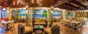 un restaurante con mesas y sillas y un mural en la pared en El Sano Banano Beachside Hotel, en Montezuma