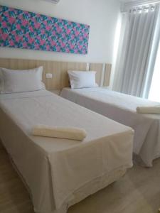 twee bedden naast elkaar in een slaapkamer bij Casa condominio fechado Arraial D’ajuda in Arraial d'Ajuda