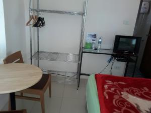 um pequeno quarto com uma mesa e uma televisão em Panna Kalong em Wiang Chiang Khong