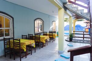 a restaurant with yellow tables and chairs in a room at Pé N'Areia in Cabo Frio