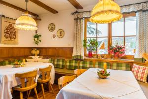 a restaurant with tables and chairs and windows at Bio Bauernhof Schoberhof in Sankt Andrä im Lungau