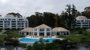 uma vista aérea de uma mansão com uma piscina em Departamento en Greenpark em Punta del Este