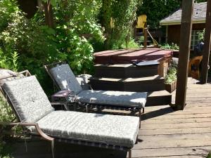 two chairs and a bench on a wooden deck at The Tuwanek Hotel and Spa in Sechelt