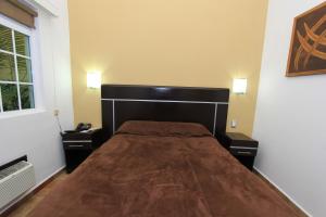 - une chambre avec un grand lit et 2 tables de chevet dans l'établissement Hotel 5 inn, à Silao