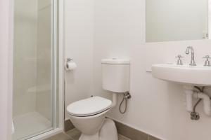 a white bathroom with a toilet and a sink at Somerset Hotel in Somerset