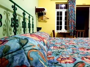 a bed with a colorful comforter on it at Parador Guánica 1929 in Guanica