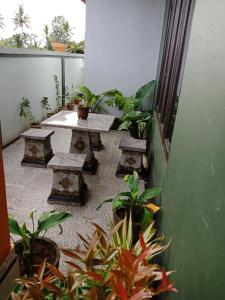 un patio con tavolo, panche e piante di Ibu Ana Homestay a Tabanan