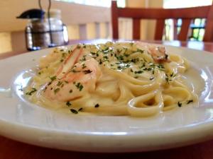 a plate of pasta with shrimp on a table at Parador Guánica 1929 in Guanica