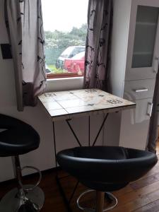 a table and two stools in front of a window at Ironsands B&B Studio Unit in Patea