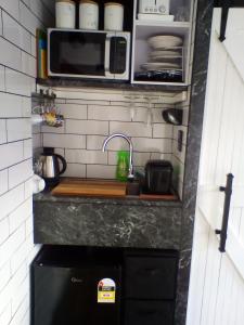 a small kitchen with a sink and a microwave at Ironsands B&B Studio Unit in Patea