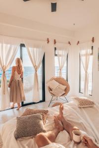 a woman standing in a bedroom looking out at the ocean at Icaco Island Village - Adults Only in Isla Mujeres
