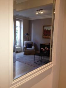 パリにあるアパルトマン シェルシュ ミディの鏡越しにリビングルームを望む
