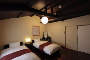 Habitación con 2 camas en una habitación en Akane an Machiya House, en Kioto