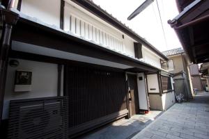 a building with a garage door and a fence at Akane an Machiya House in Kyoto