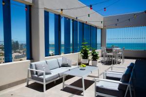 a balcony with a couch and a table and chairs at The Gerald Apartment Hotel in Geraldton