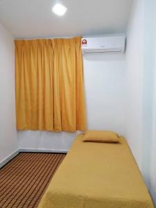 - une chambre avec un lit et une fenêtre avec un rideau dans l'établissement NAZ Homestay, à Jitra