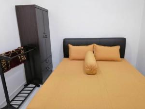 a bed with a black headboard and a yellow pillow at NAZ Homestay in Jitra