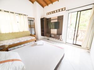 sypialnia z łóżkiem i dużym oknem w obiekcie Punta Caribana Casa Hotel w mieście Necoclí