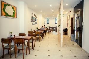 a restaurant with tables and chairs and people sitting at tables at Gardenia Hue Hotel in Hue