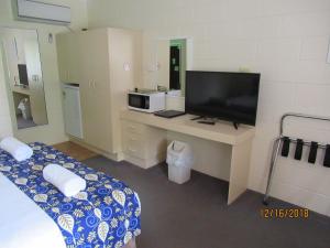 a hotel room with a bed and a television at Moruya Motel in Moruya