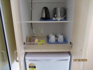 a white refrigerator freezer sitting inside of a kitchen at Moruya Motel in Moruya