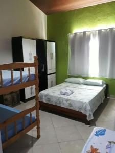 リオ・ダス・オストラスにあるSuítes a Beira Marのベッドルーム1室(ベッド1台、二段ベッド1組付)